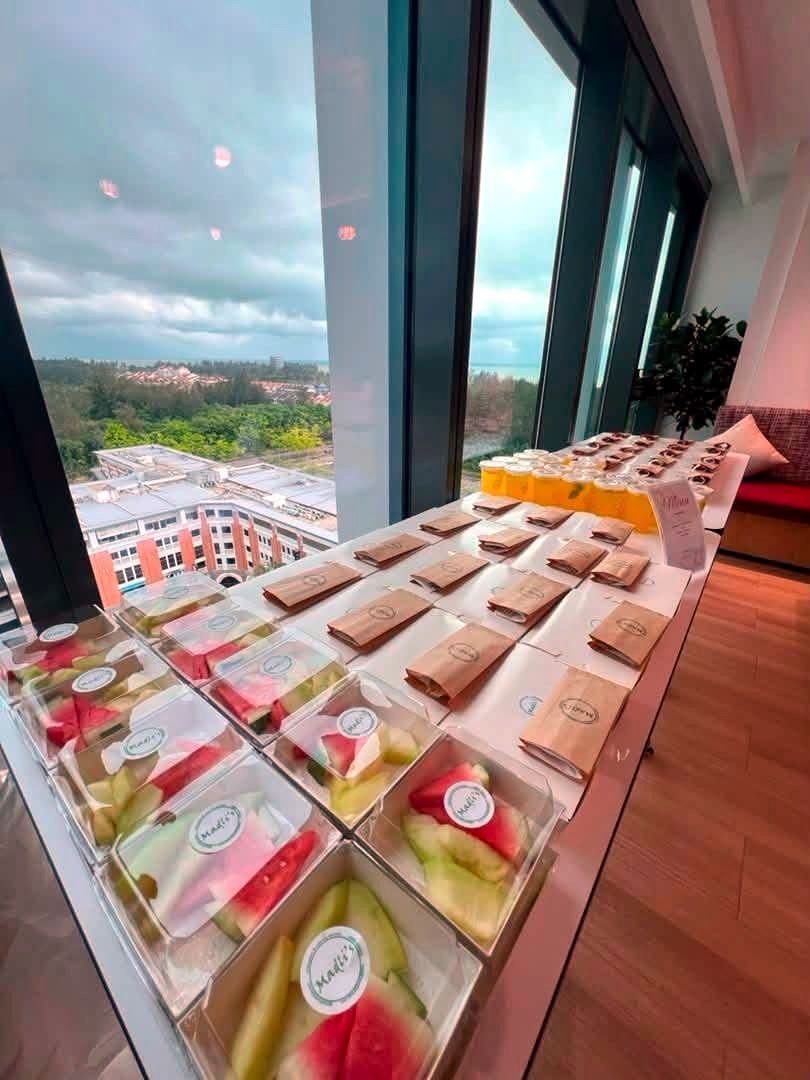 Madli's packed fruit boxes and meal bags laid out for a corporate event overlooking Miri