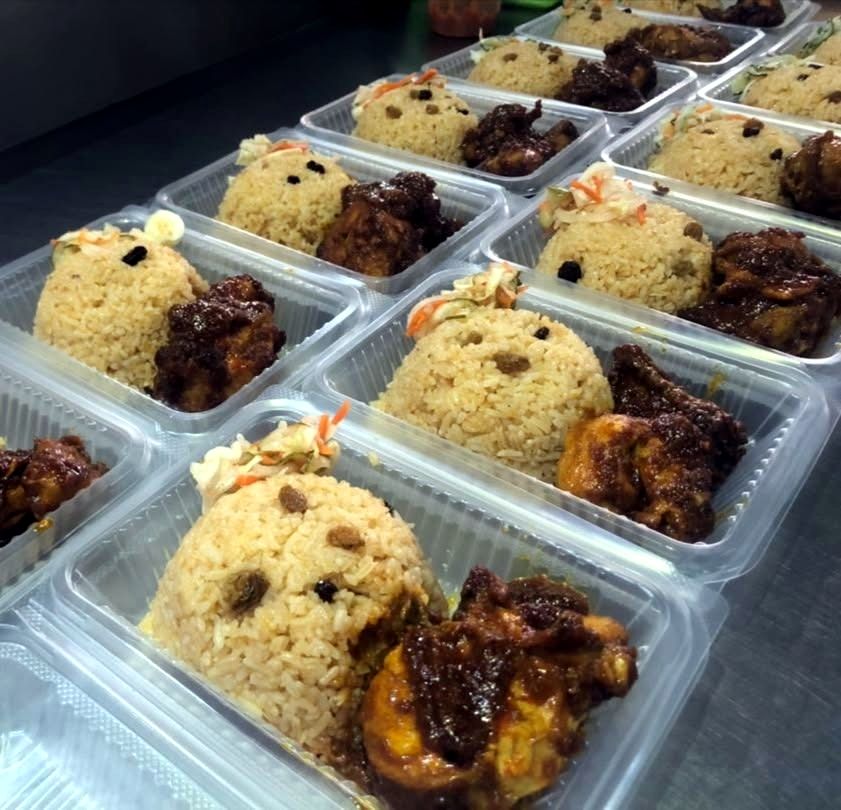 Packed nasi tomato with ayam masak merah for event delivery